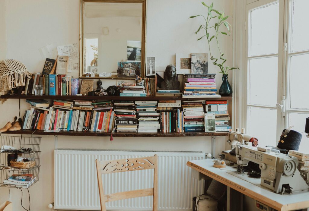 pexels-photo-15124880-15124880 Warm and inviting home office featuring a sewing machine, bookshelves, and vintage decor. Perfect for creative inspiration.