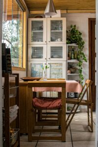 Warm and cozy kitchen featuring wooden furniture and green plants.
