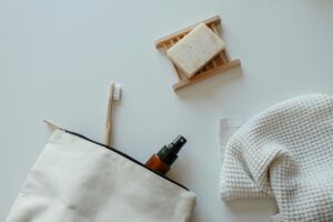 A flat lay of eco-friendly bathroom essentials including soap, towel, and spray bottle.